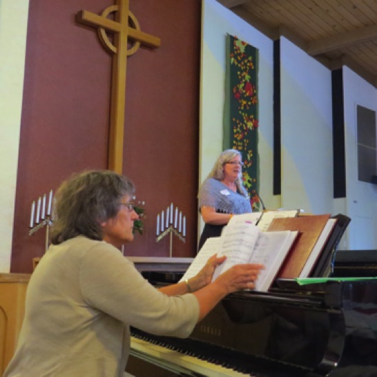 Our accompanist Pam, and Roberta reading a few notes from those who could not join us