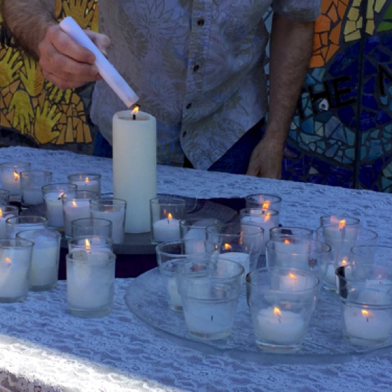 Candles are lit in memory of loved ones from a central light